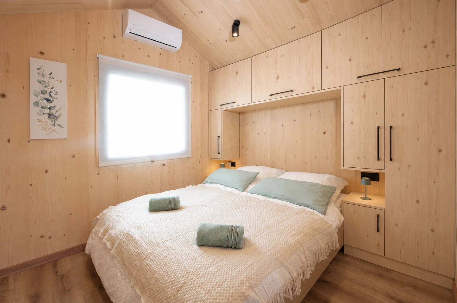Schlafzimmer mit deckenhoher Fichtenholz-Einbauwand und senkrechter Maserung